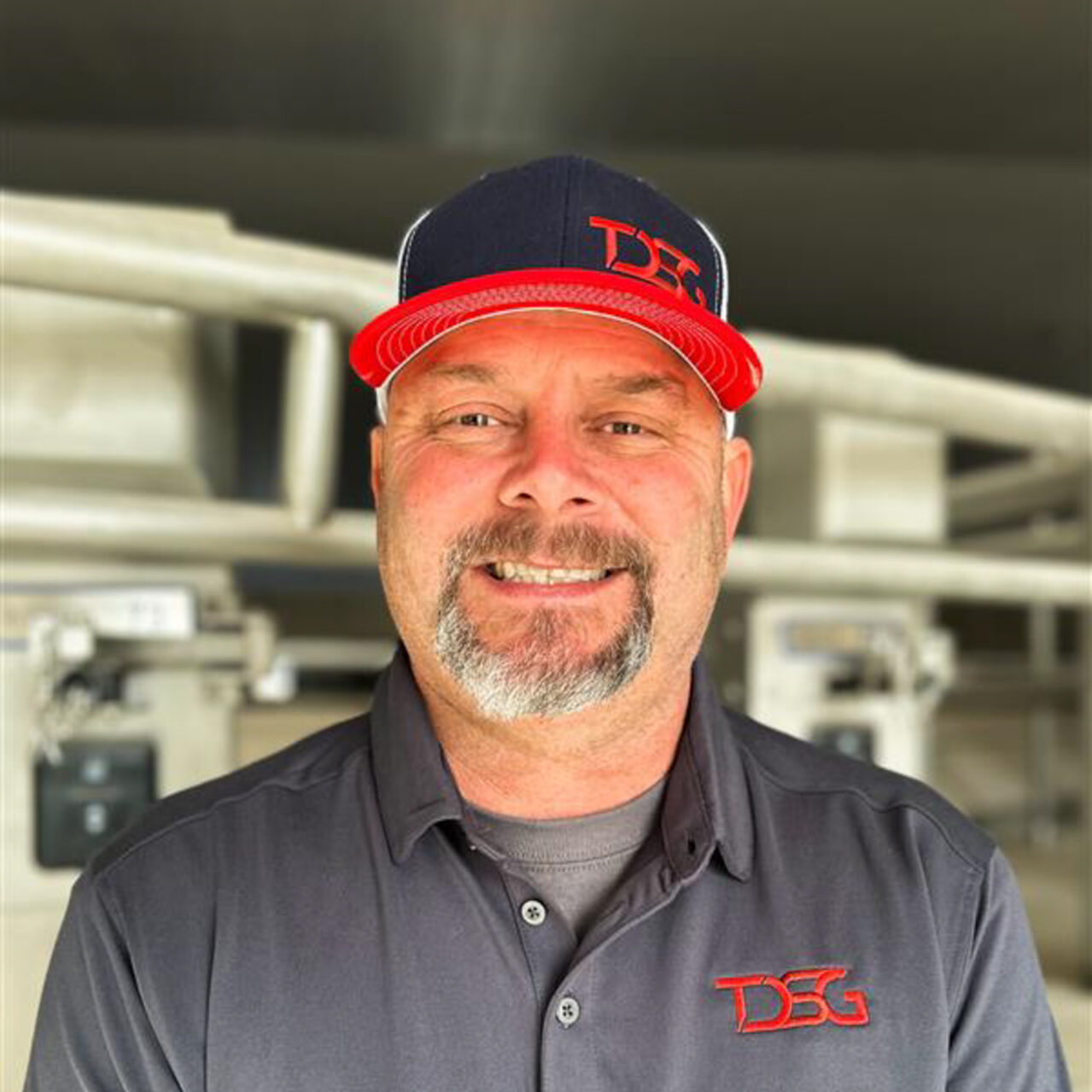 Jeff Blesy standing in a milking barn with a blurred background.
