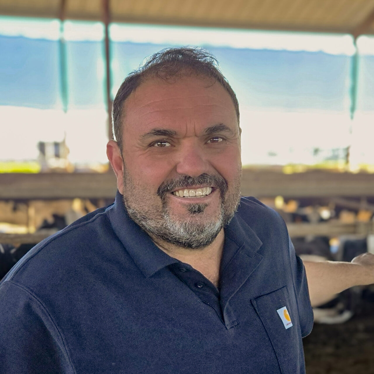 Jr DaPonte standing inside a dairy barn with a blurred background.
